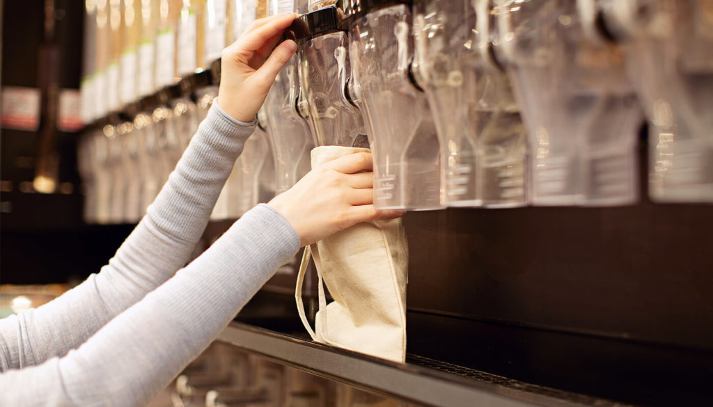 Person dispensing food into reusable container