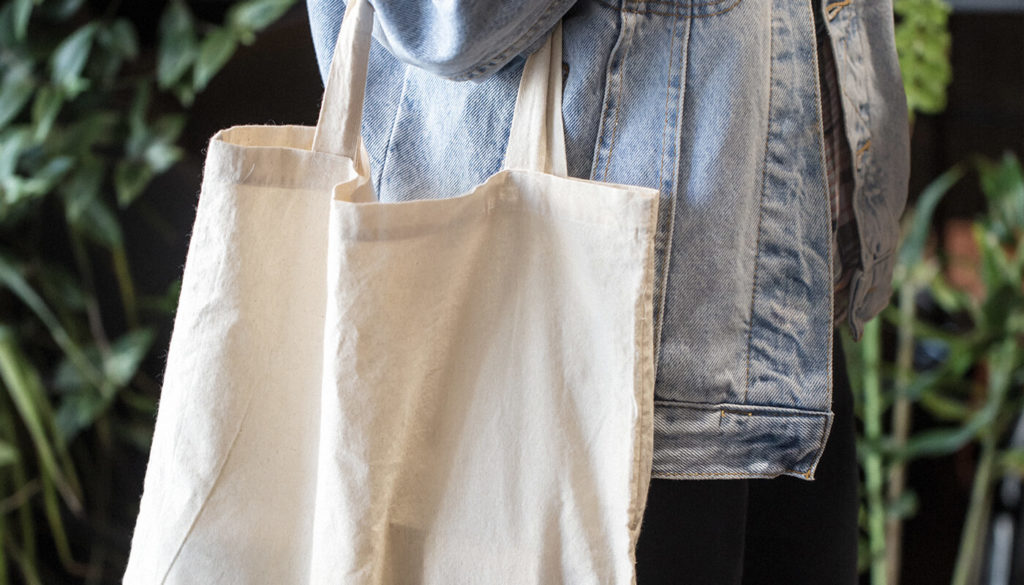 Person carrying a canvas shopping bag